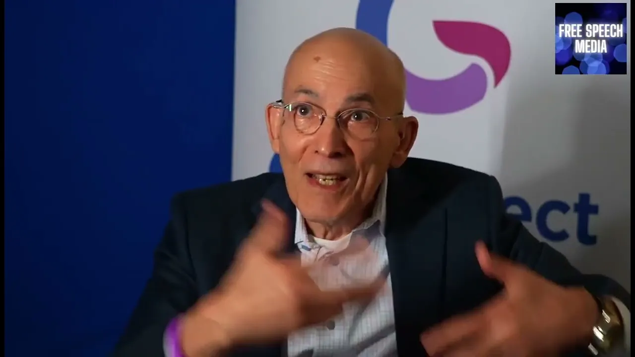 Stephen Levine gesturing while speaking in front of a Genspect backdrop