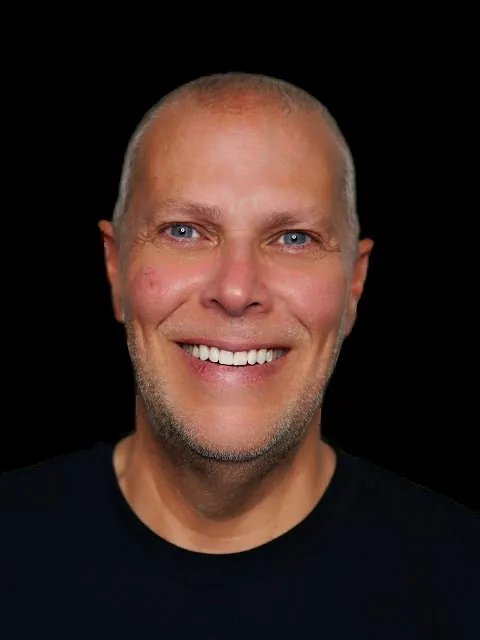 Mike Bayer, head and shoulders, smiling, on a black background