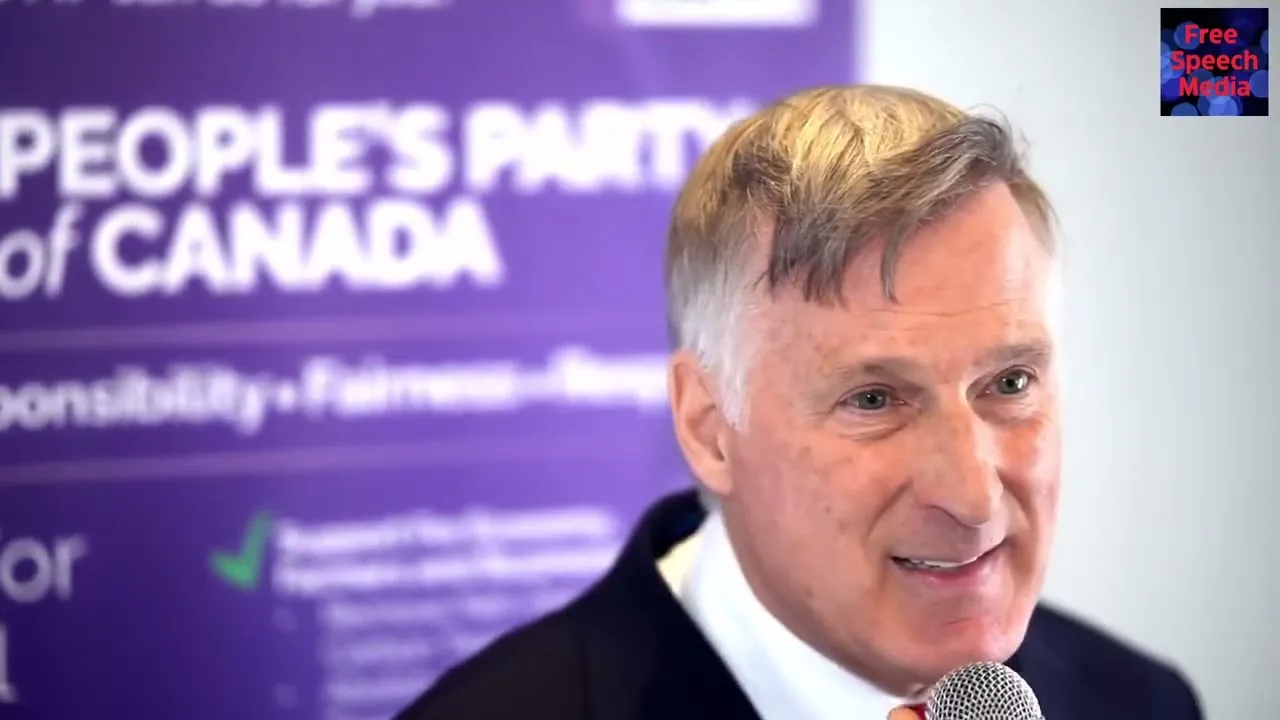 Maxime Bernier smiling in front of a purple banner