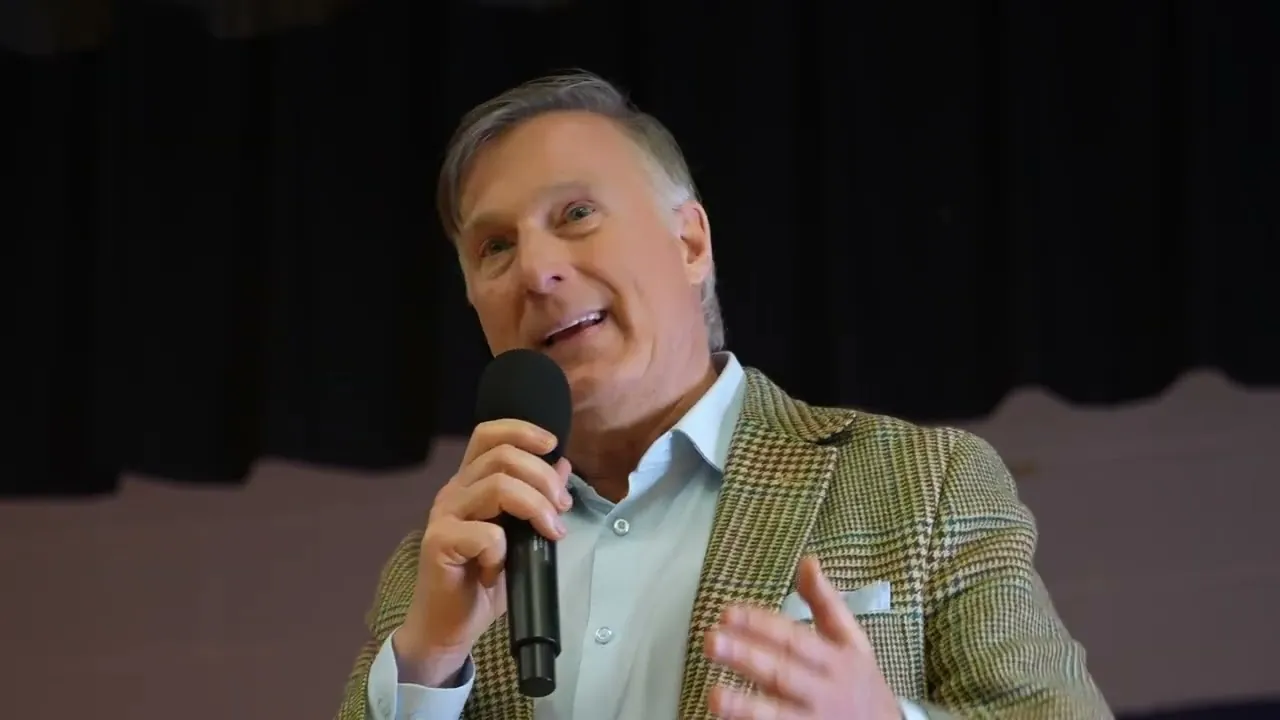 Maxime Bernier speaking with a microphone in a hall
